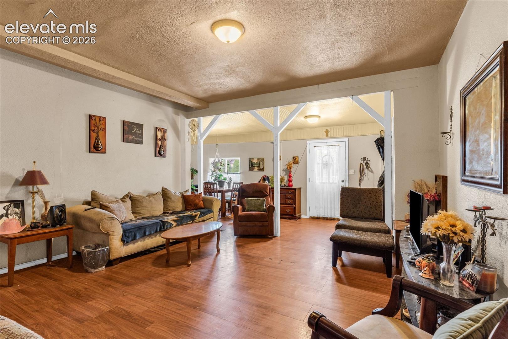 Wood-finish flooring throughout, with a framed entryway creating a defined living space