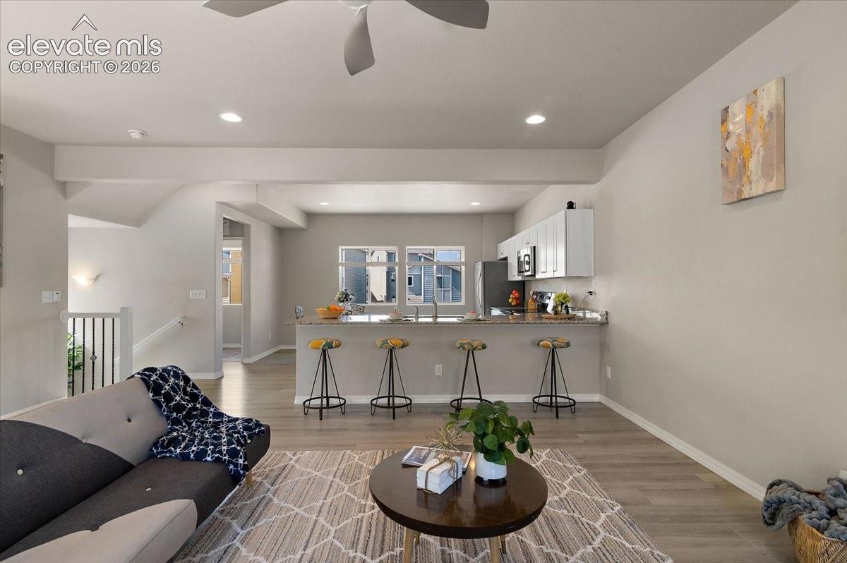 Open-concept living area w recesselighting, and a ceiling fan