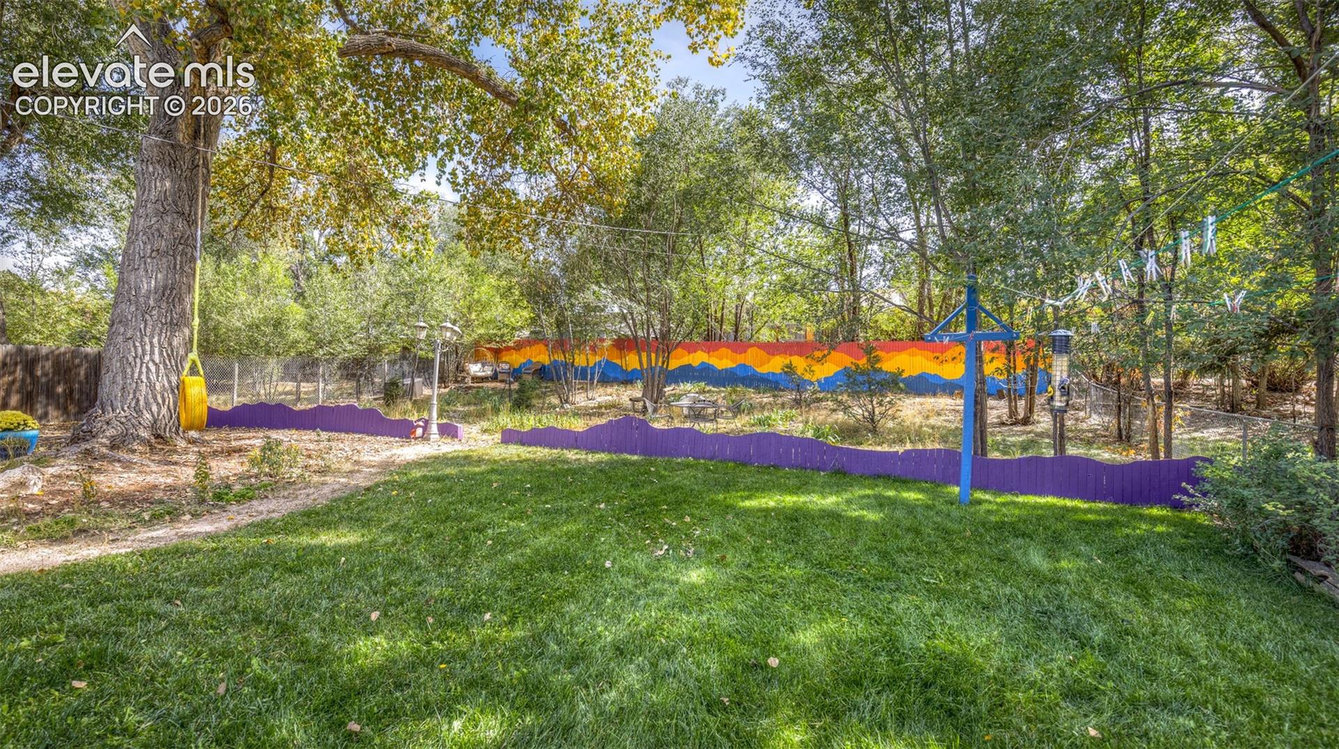 Manicured lawn with mature trees and vibrant fencing