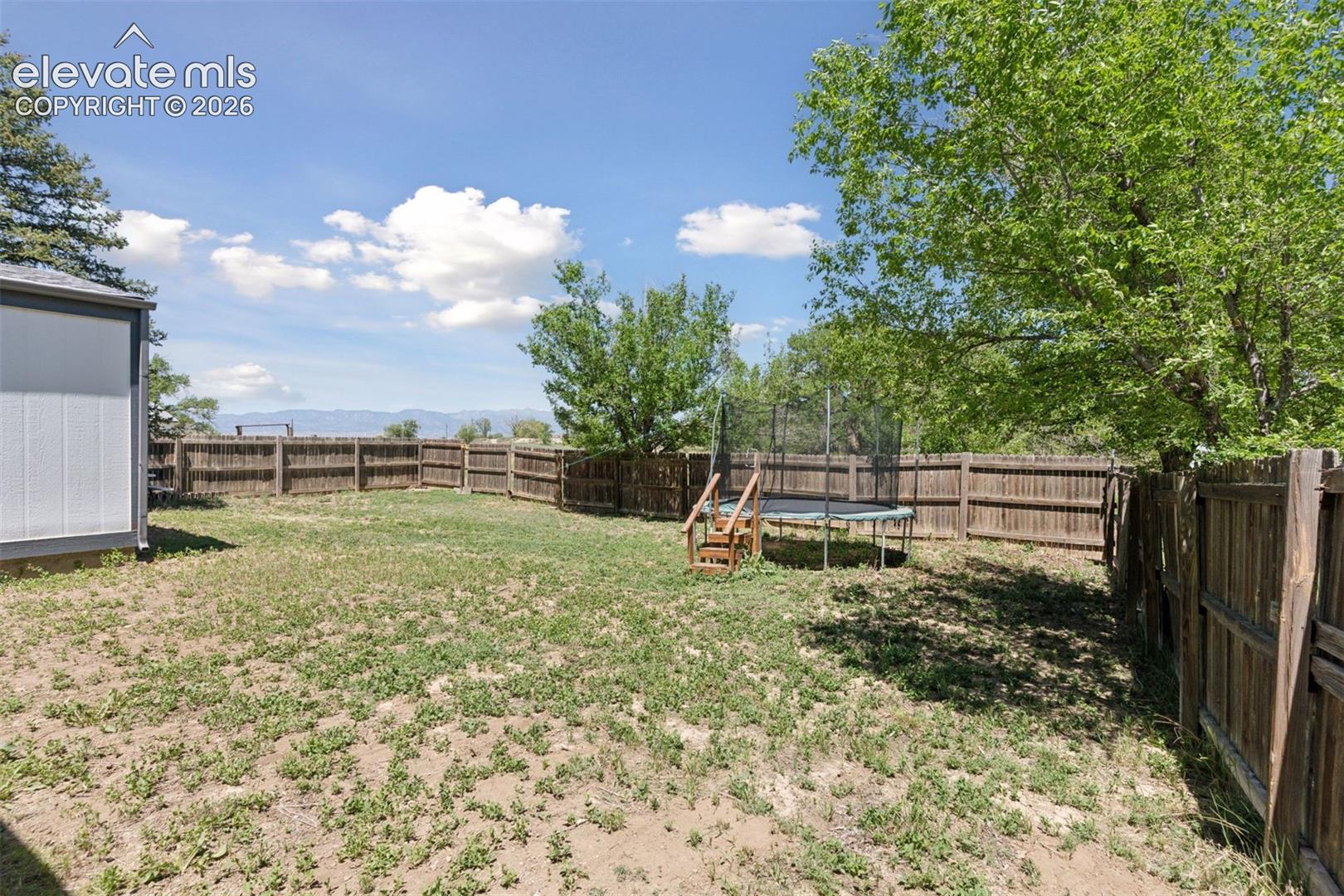Fenced yard area associated with the second single-family residence, offering private outdoor space w/views of the mountains in the distance.