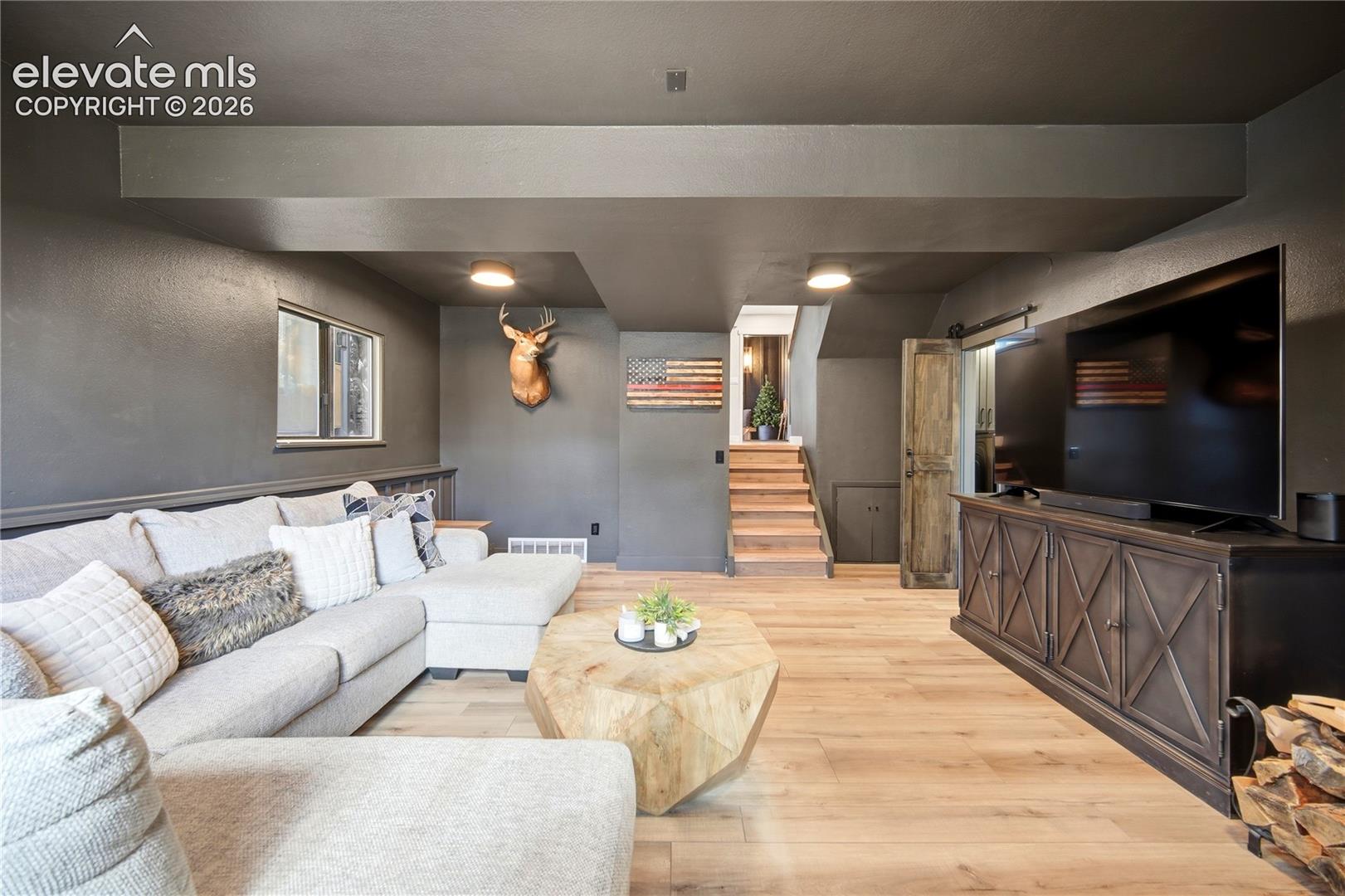 Wood-finish flooring, recessed lighting, barn-style sliding door, and neutral wall color