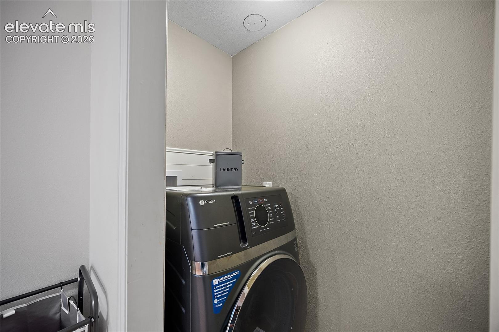 Dedicated laundry area featuring a front-loading appliance