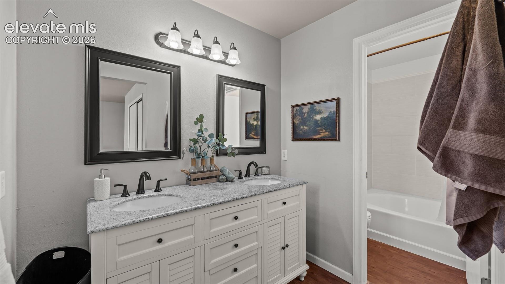 Dual vanity with granite countertop, undermount sinks, and black-finish hardware