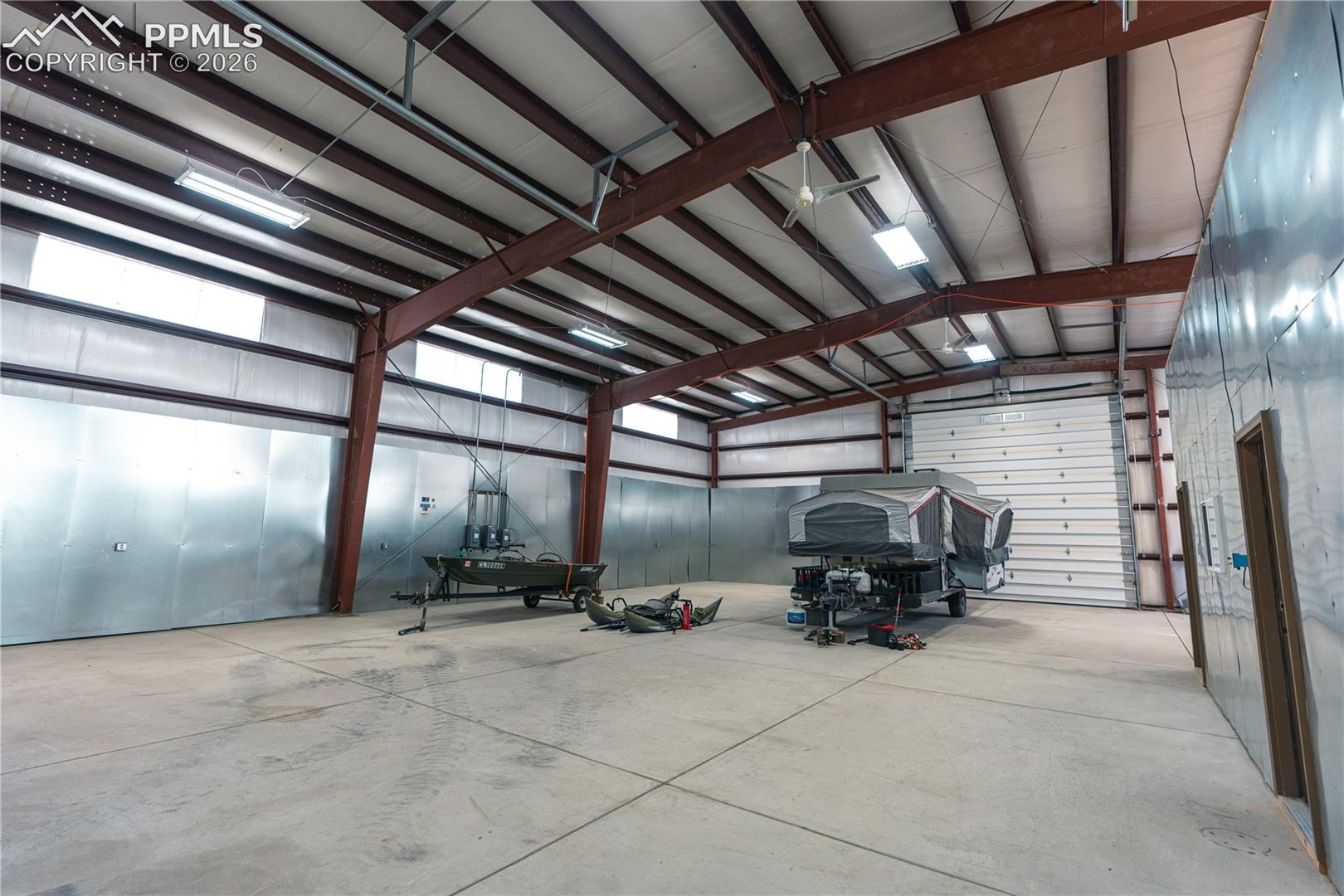 Spacious interior with concrete flooring and exposed metal beam construction