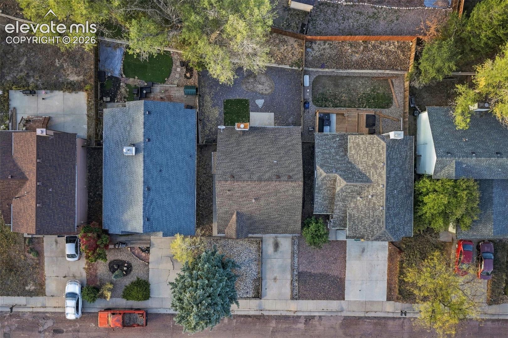 Aerial perspective featuring shingle-roofed structures, paved driveways, and established tree canopy
