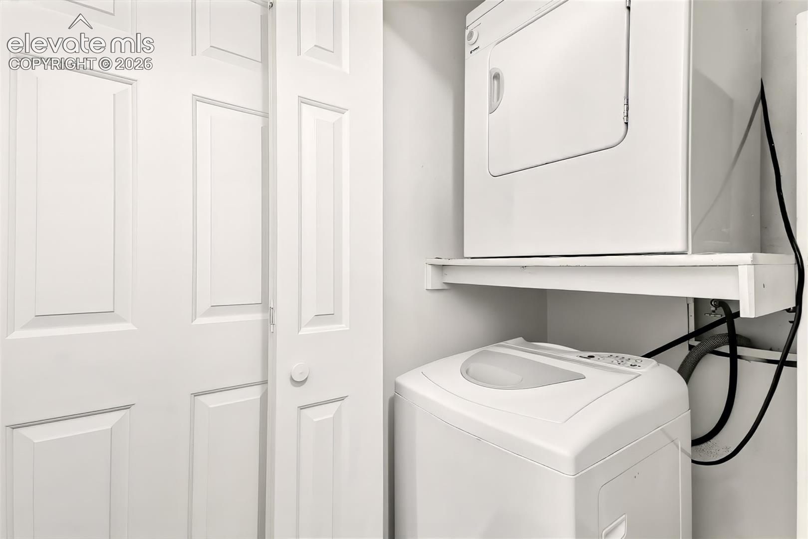 Laundry area featuring stackable washer/dryer. 