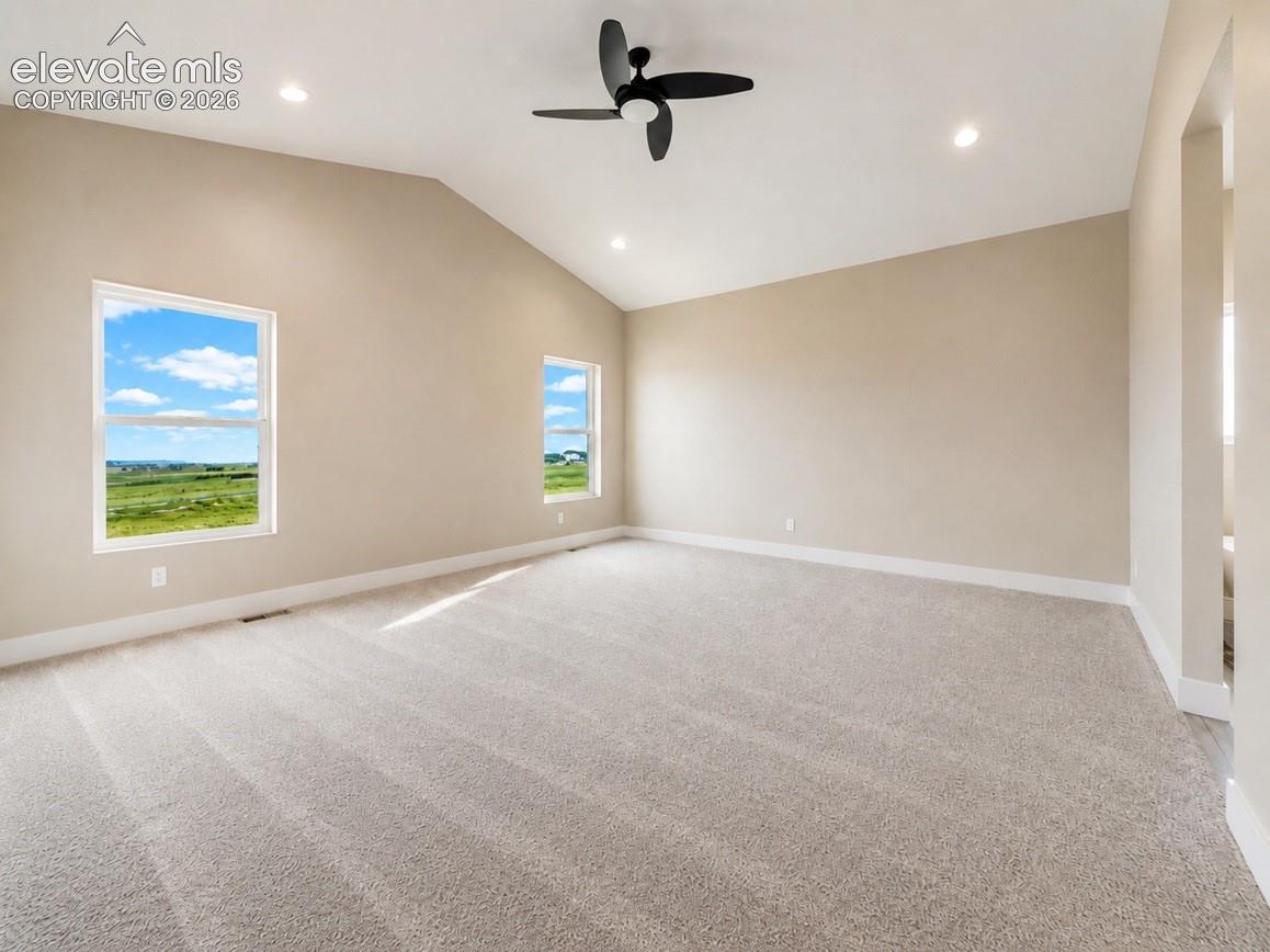Spacious room featuring a vaulted ceiling with a ceiling fan, recessed lighting, and soft neutral carpeting