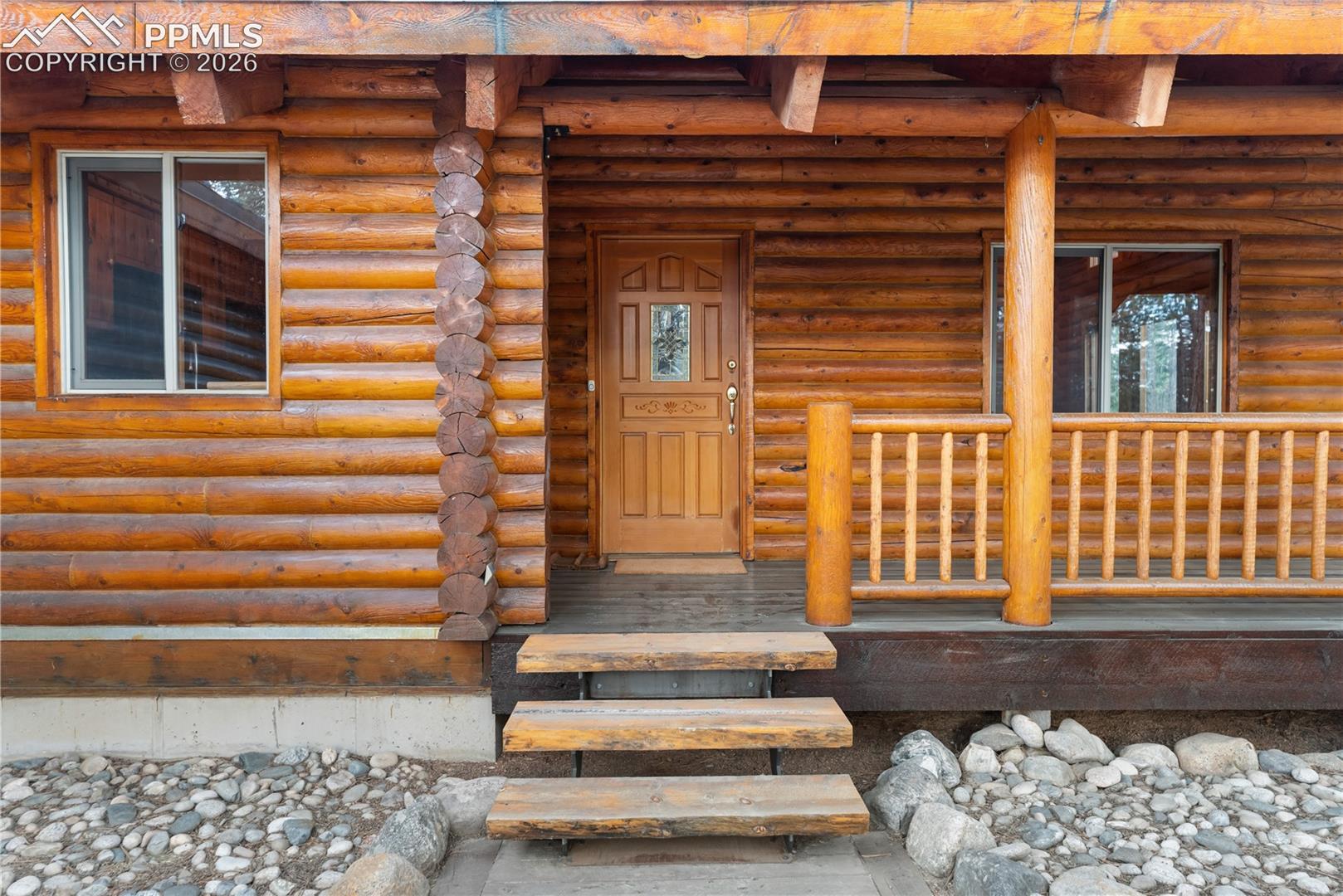 Entrance to property featuring log exterior and a porch