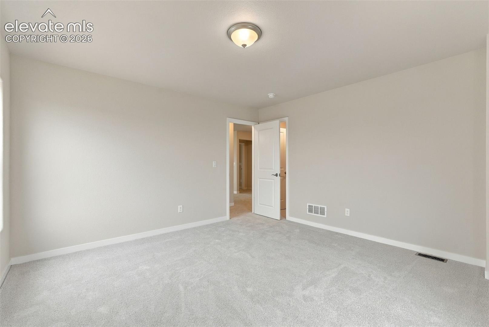 Neutral wall paint, high-pile carpeting, and a flush-mount ceiling light fixture with a white dome shade