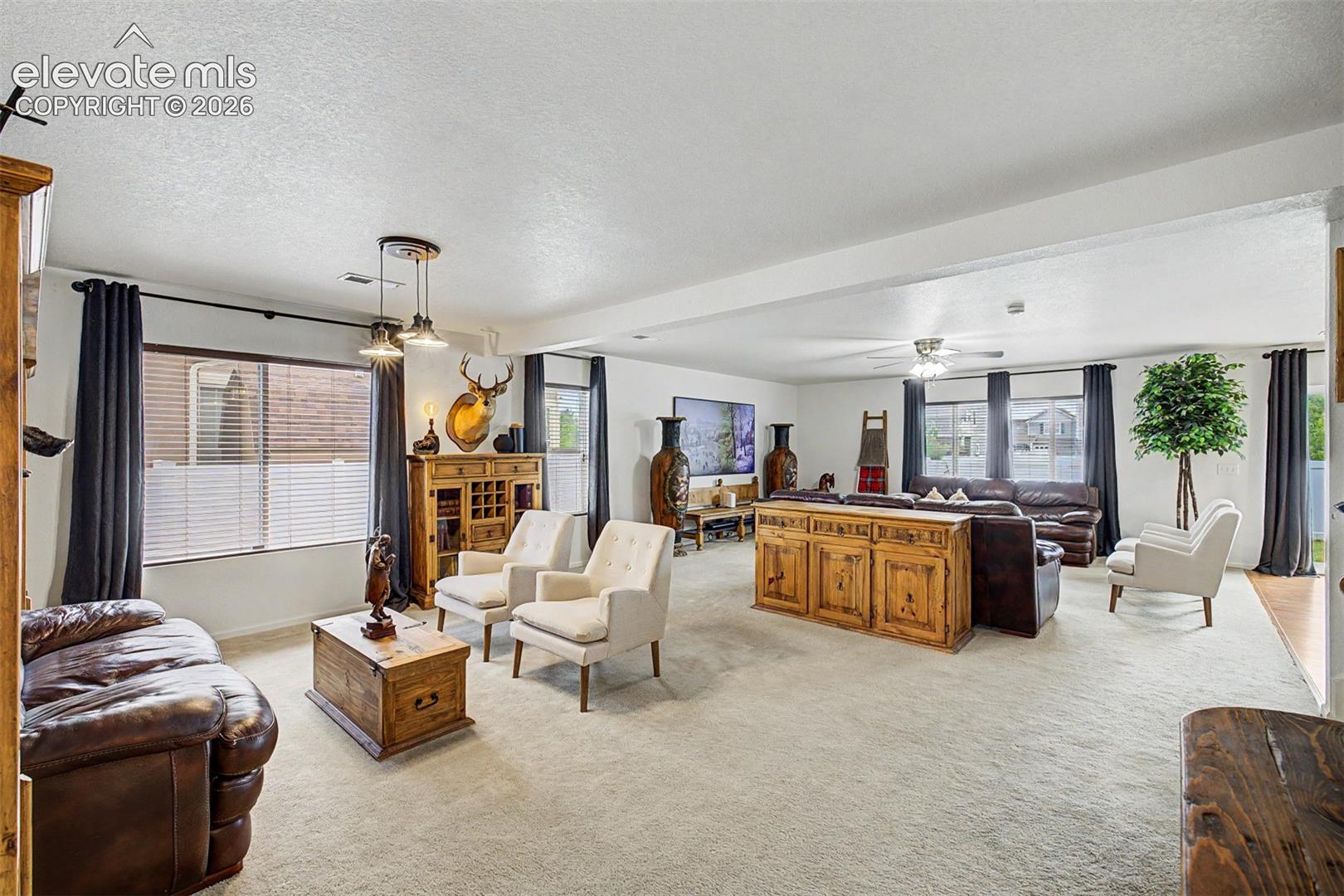 Modern pendant lighting, a carved mirror, and statement furnishings fill this room with texture and warmth, making it as visually captivating as it is comfortable.