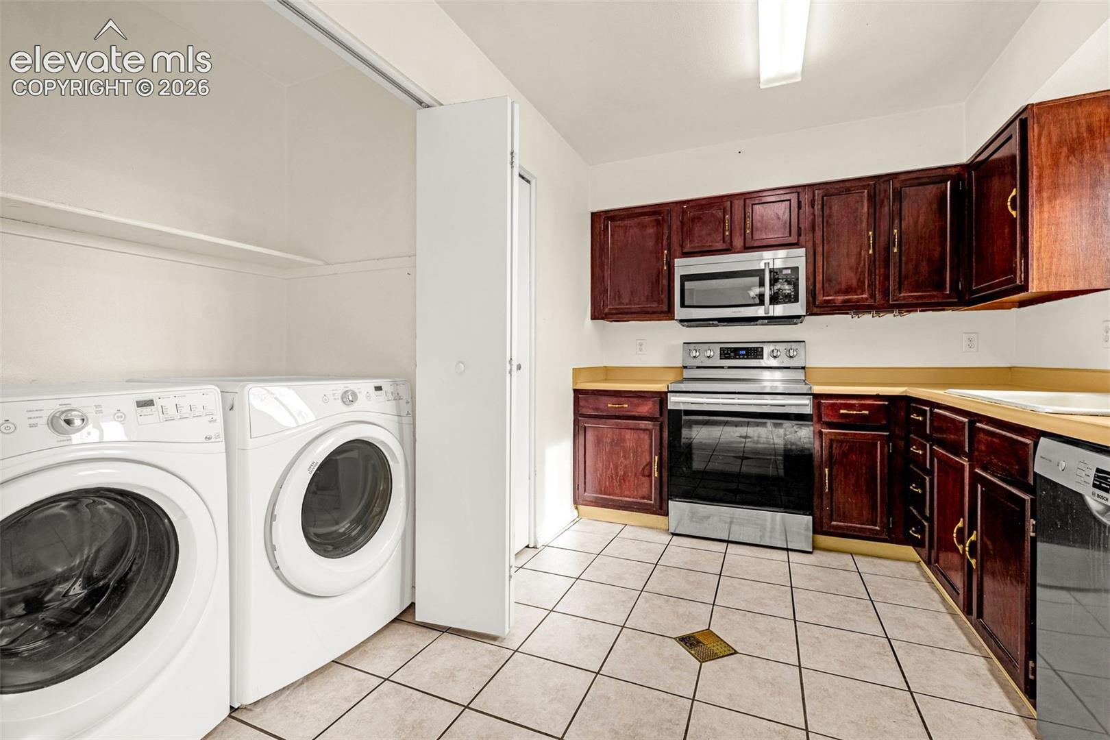 Kitchen and laundry closet - newer appliances including Bosch SilencePlus dishwasher, Kenmore refrigerator, glass top stove and Whirlpool Duet HE washer and dryer.