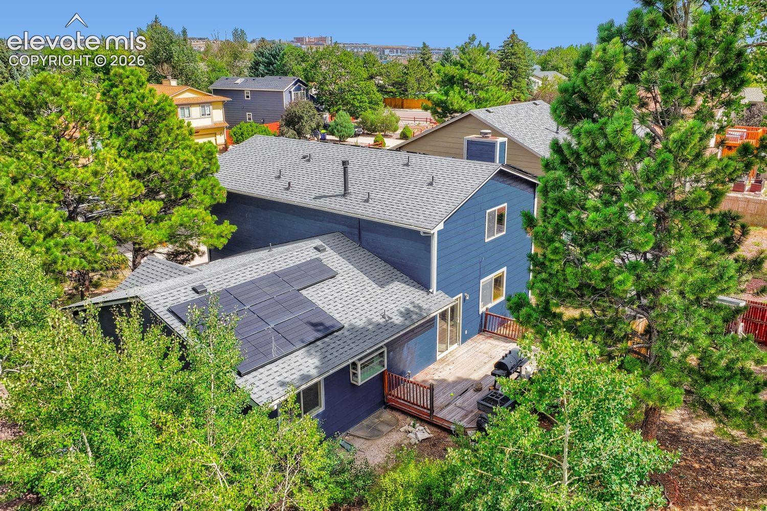 Two-story exterior with blue siding, a multi-level roofline, and integrated solar panels