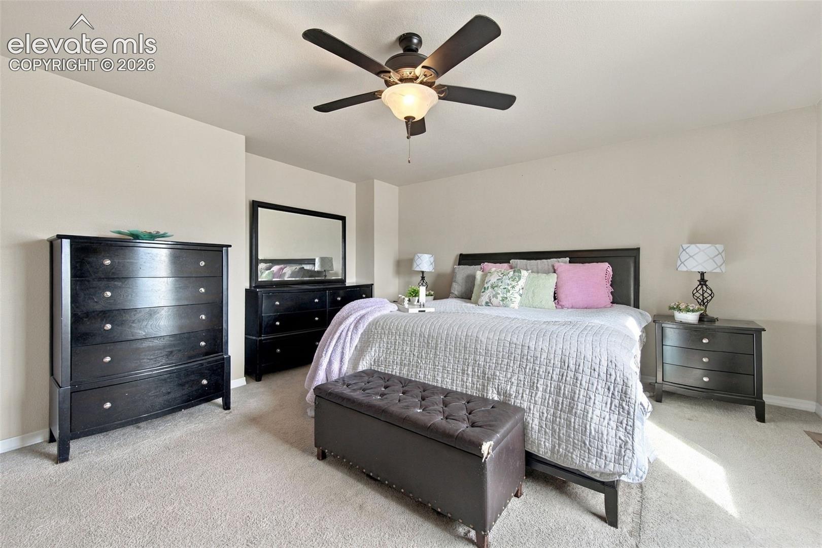 Spacious interior featuring neutral wall tones, carpeted flooring, and a central ceiling fan with integrated lighting