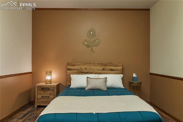 Bedroom featuring baseboards and wood finished floors
