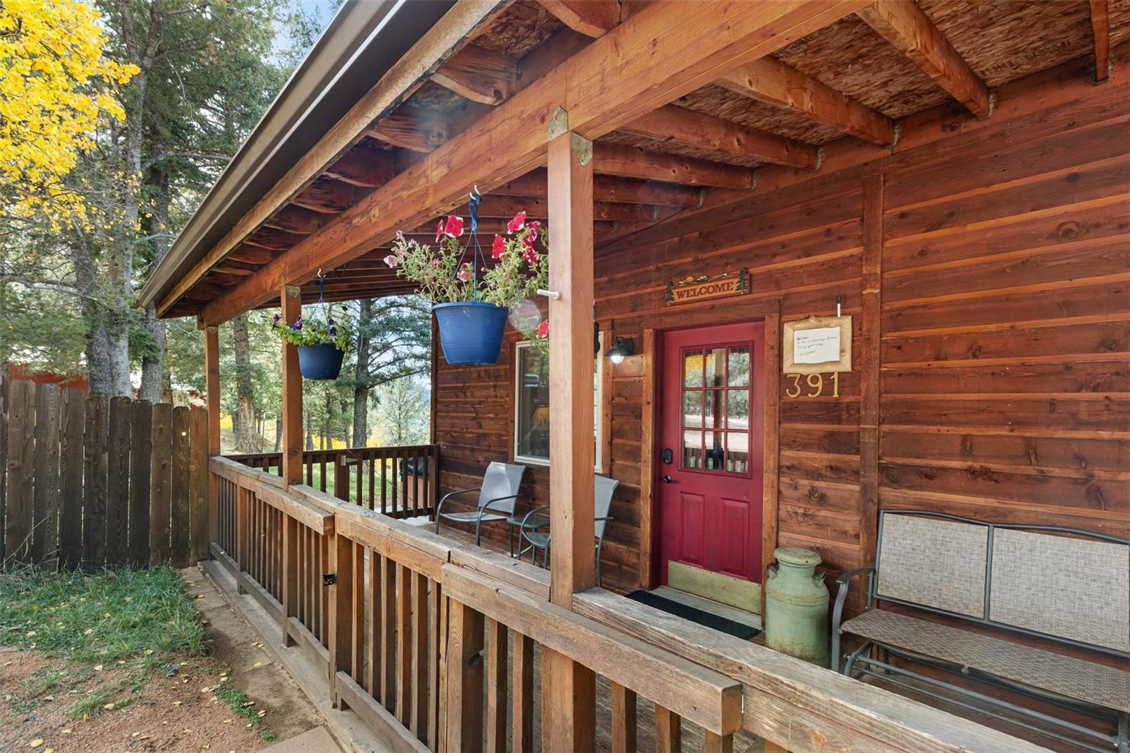 Wood-sided exterior featuring an expansive covered porch with wood railing and columns
