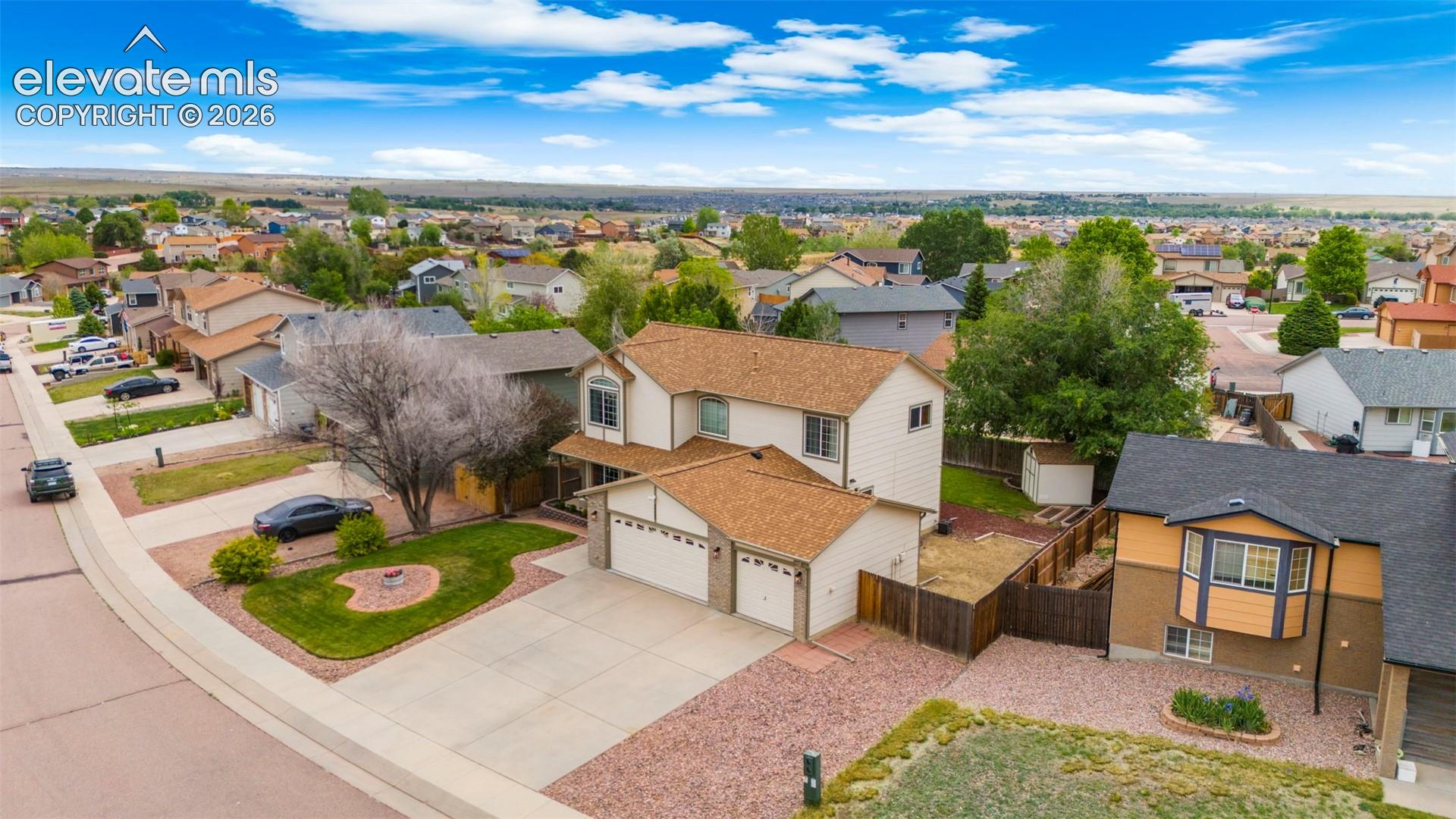 Two-story residence with a three-car garage and a paved driveway