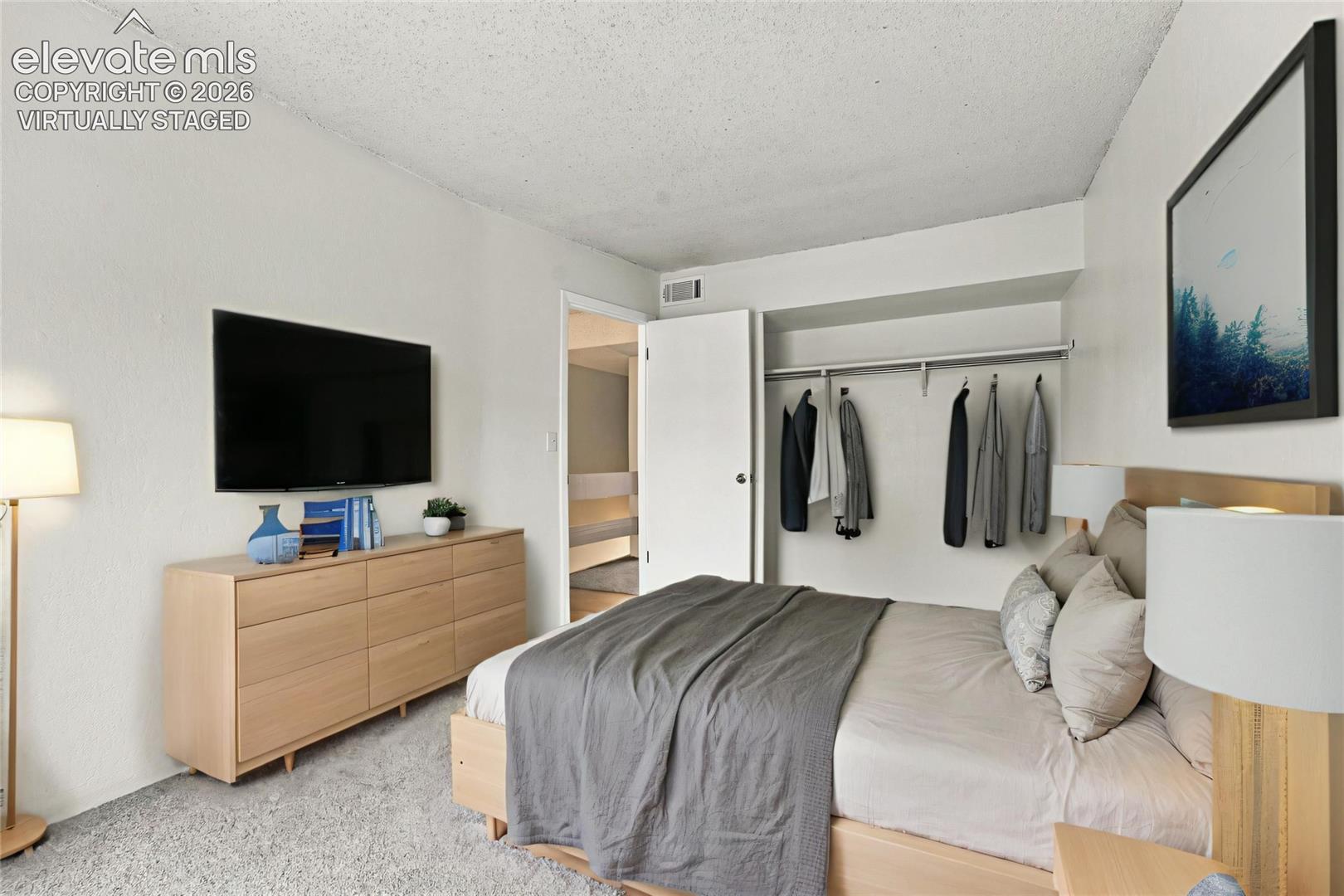 Bedroom featuring neutral carpeting and an open-concept closet with integrated shelving
Virtually Staged