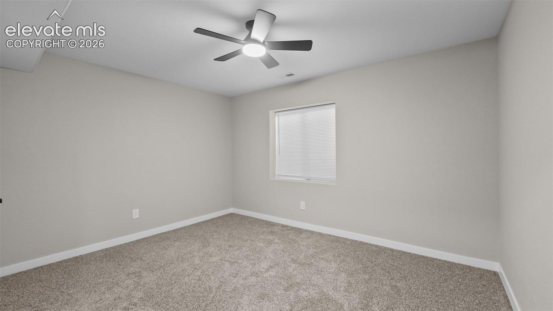 Carpeted flooring, neutral wall finish, recessed window with blinds, and a ceiling fan