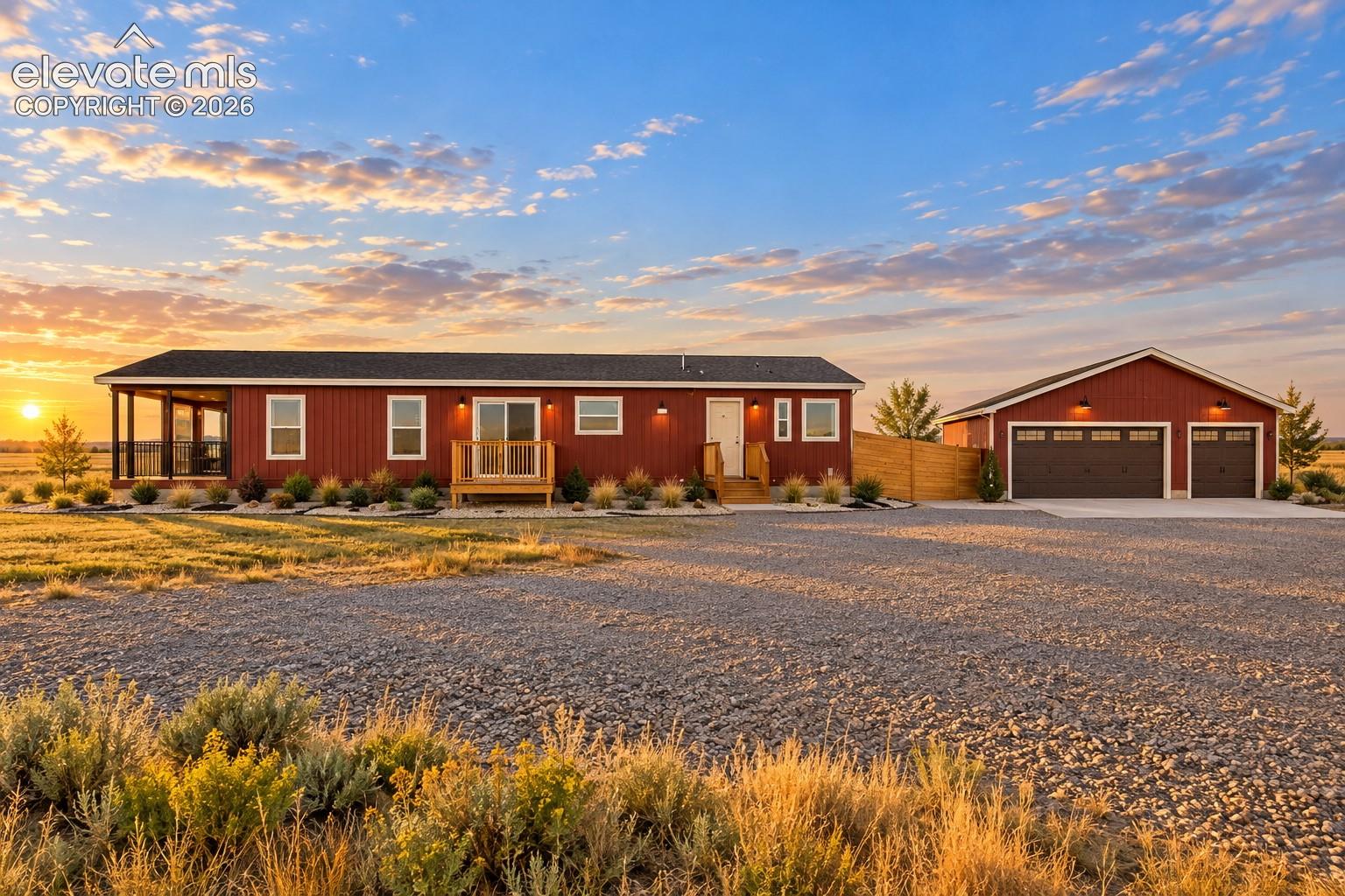 Exterior – Broad exterior view highlights the home’s elongated single-level profile, covered porch, multiple exterior access points, low-maintenance 