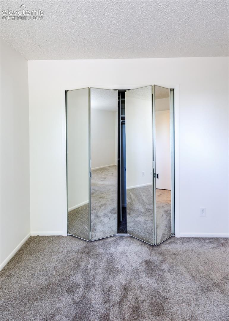 Four-panel mirrored bi-fold closet doors featuring metal framing and integrated shelving