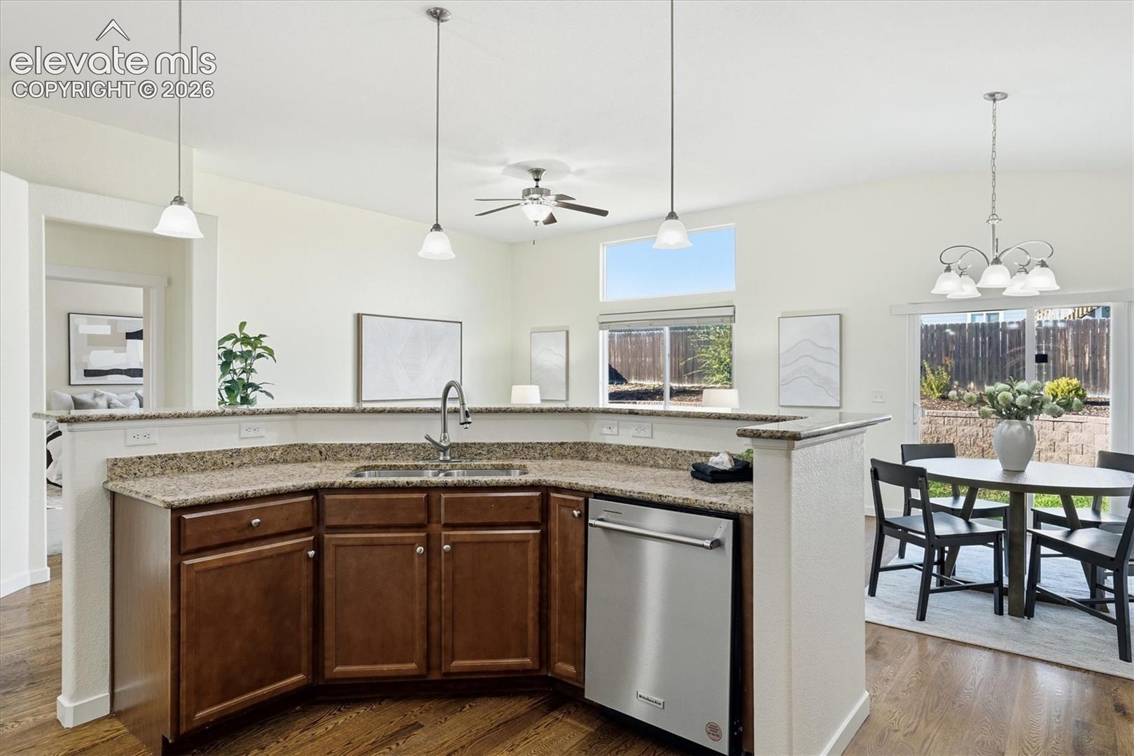 Kitchen island with a stainless steel sink, a stainless steel dishwasher, and a stone-finish countertop