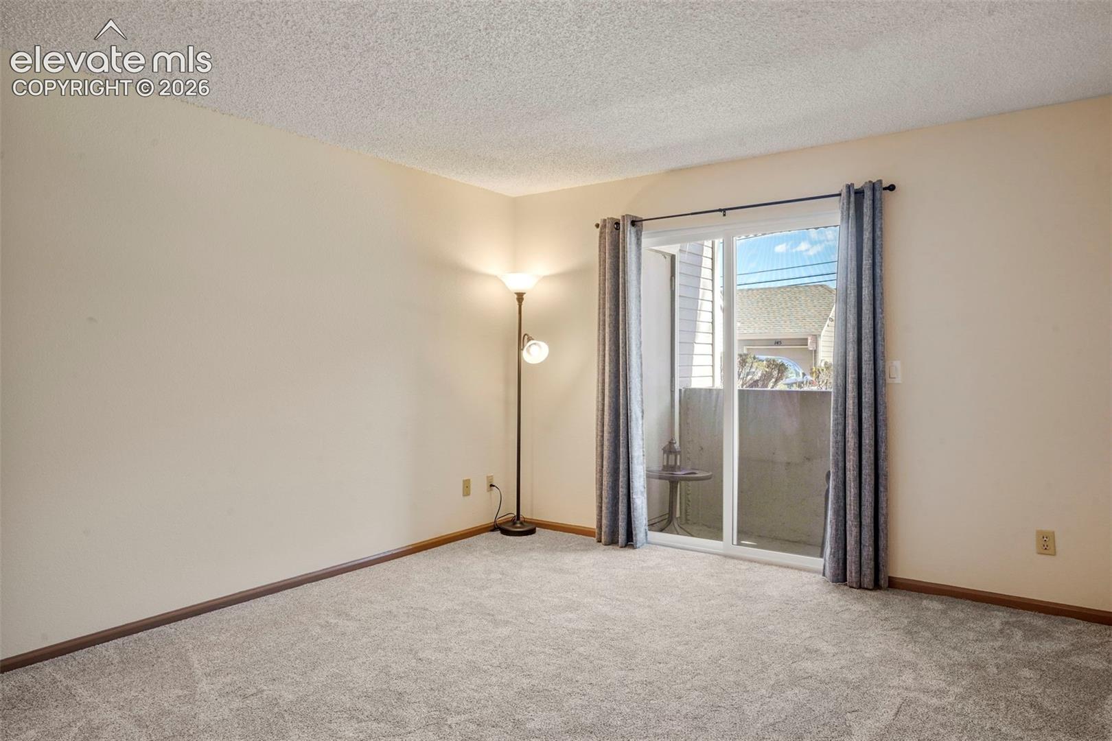 Spare room featuring a textured ceiling and carpet floors