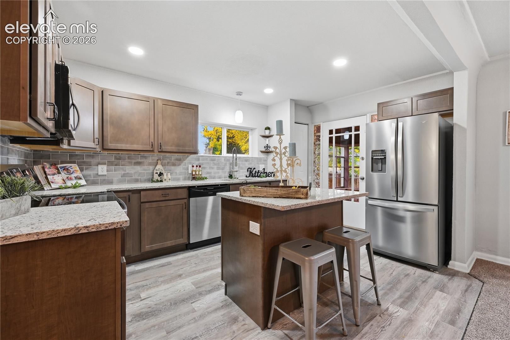 This kitchen has access to the sun room off the back. The back door is original with glass block sidelights.