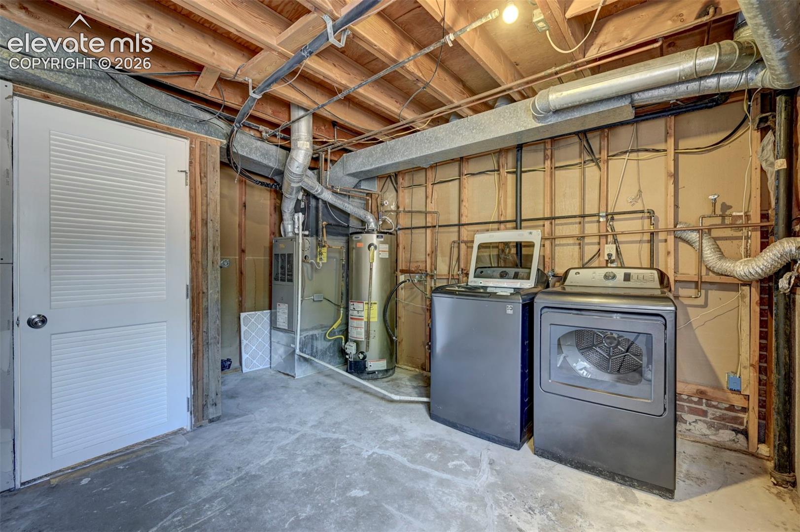 Utility area featuring a concrete floor, exposed wood ceiling joists, white louvered door, water heater, and HVAC system