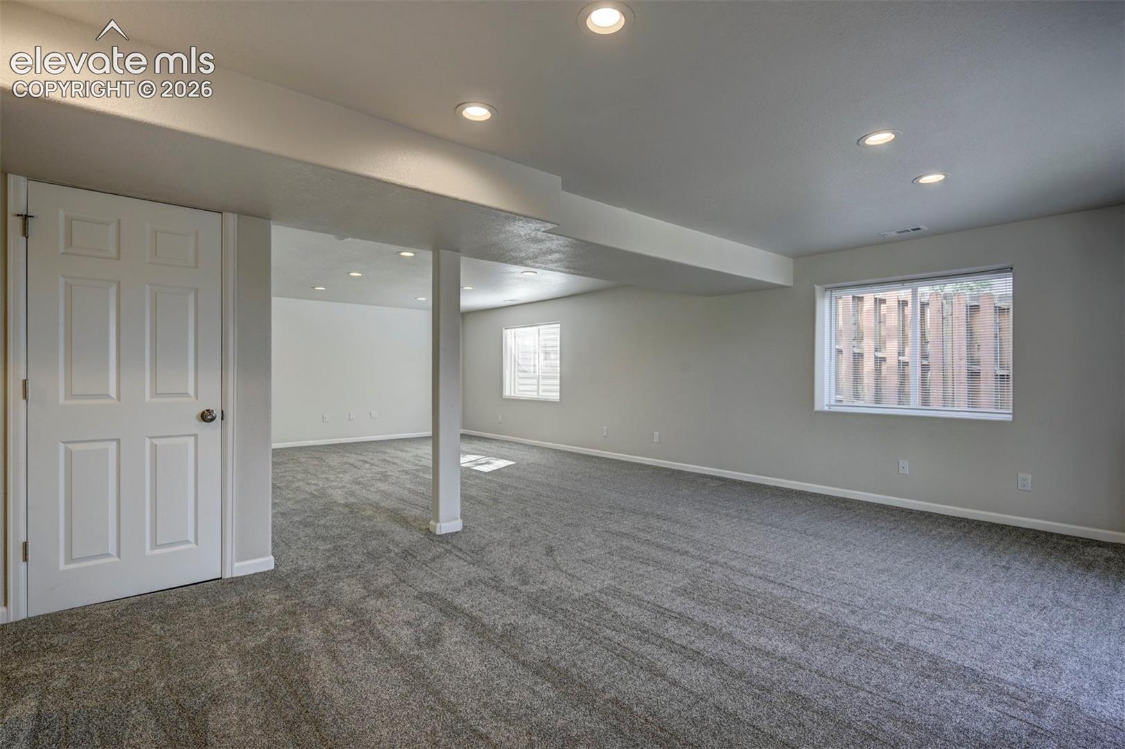 Open-concept interior featuring wall-to-wall carpeting, recessed lighting, and white six-panel doors