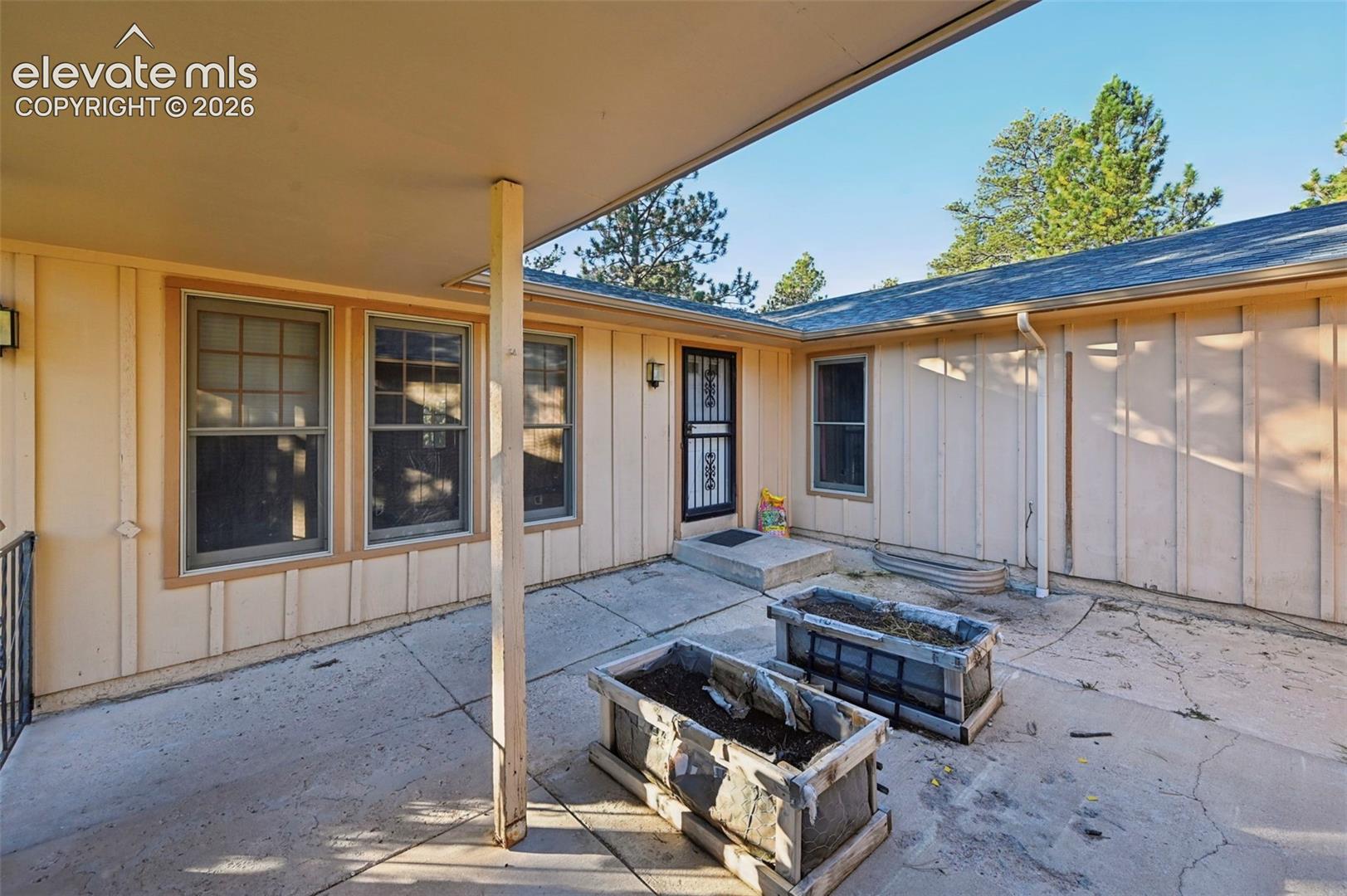 Covered patio area with concrete surfacing and built-in planters