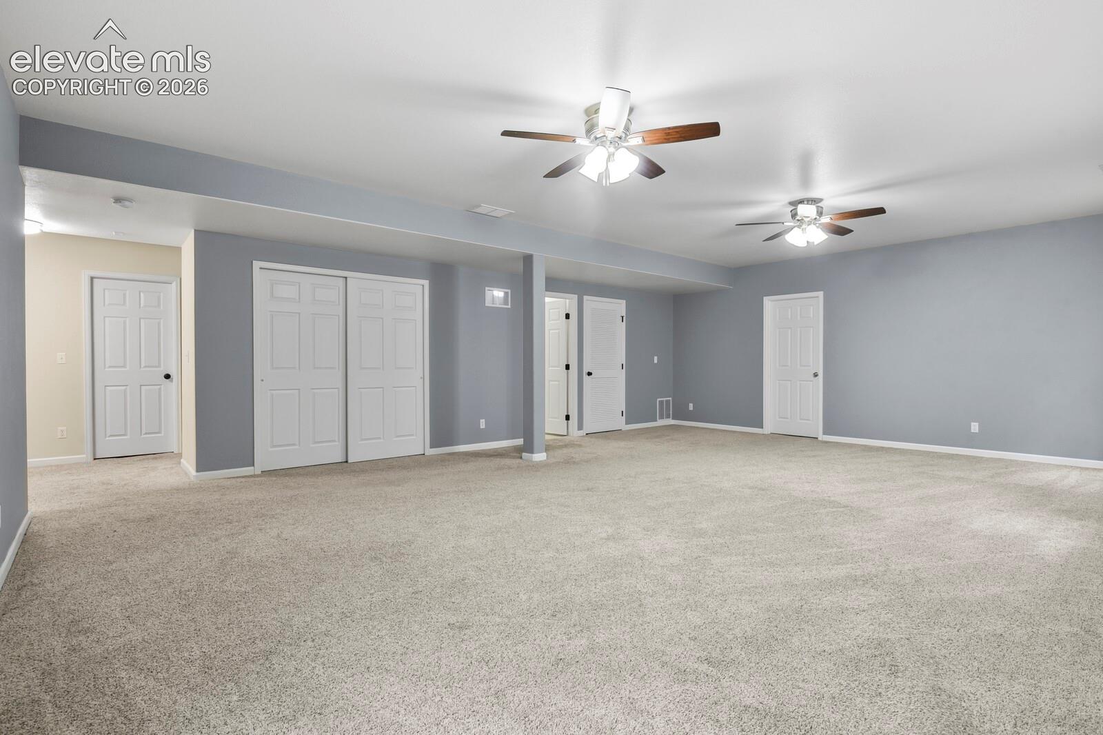 Spacious room featuring light beige carpeting and light grey walls