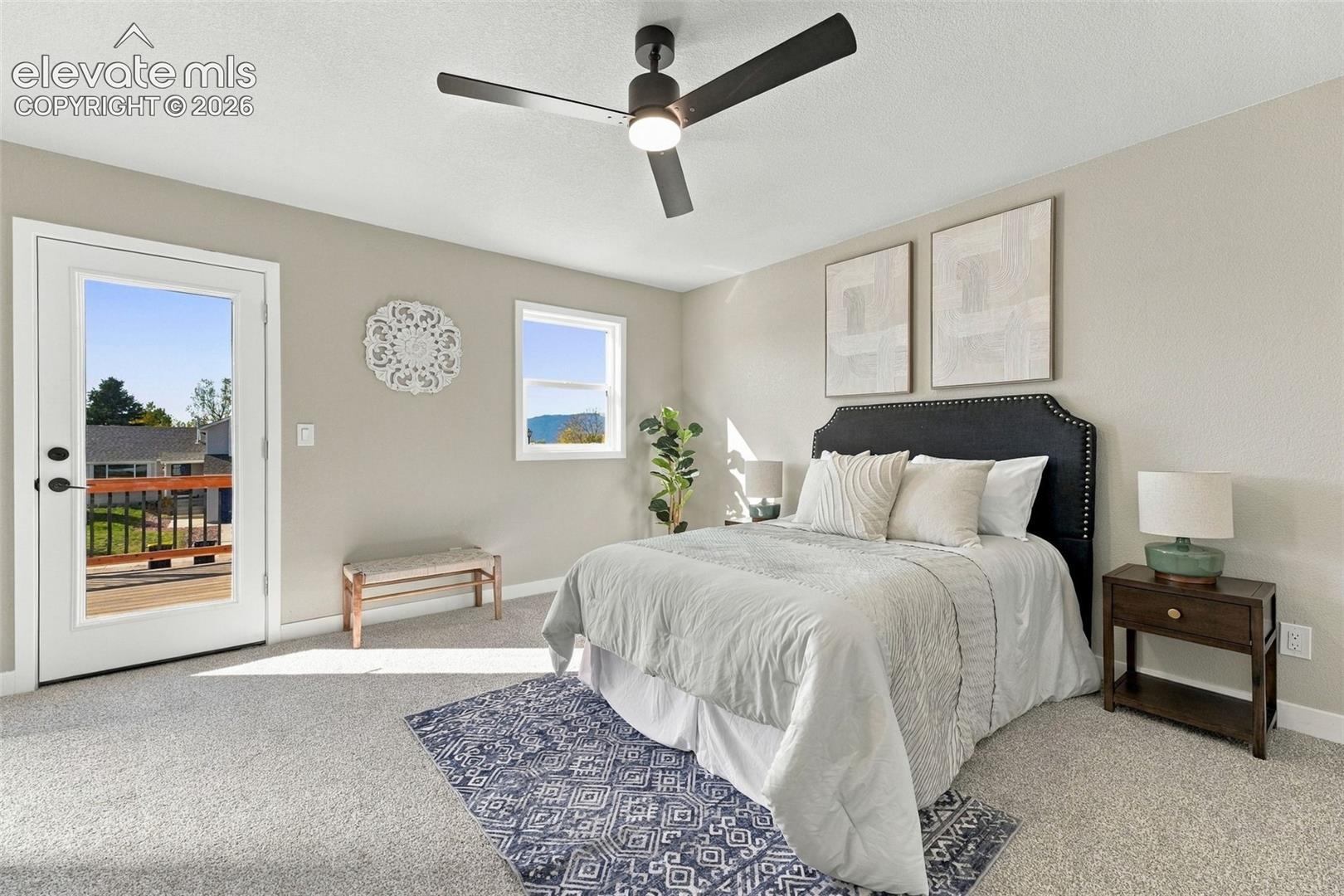 Neutral-toned interior featuring wall-to-wall carpeting, a matte black multi-blade ceiling fan with integrated lighting, and a glass-paneled exterior door