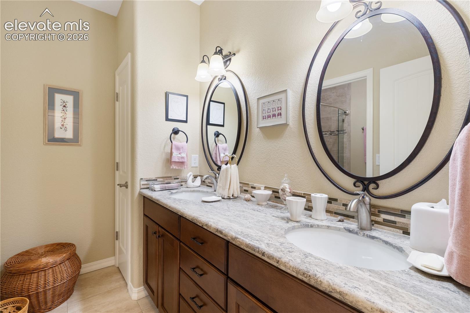 Lower bathroom with dual vanities, shower/tub combo, toilet.