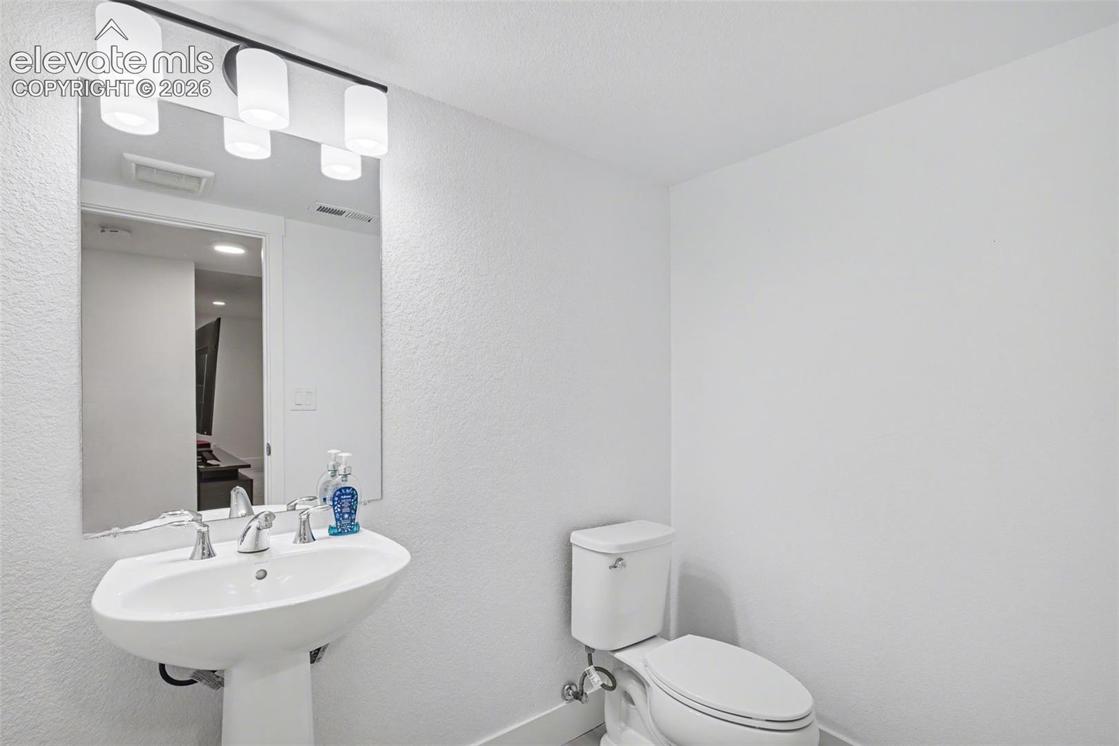 Bathroom with baseboards and a textured wall