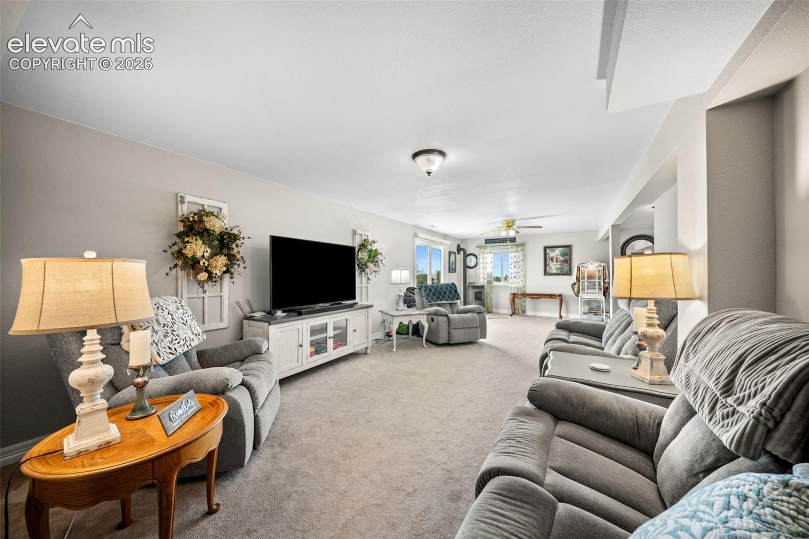 Expansive living area featuring light gray walls, plush carpeting, and recessed lighting