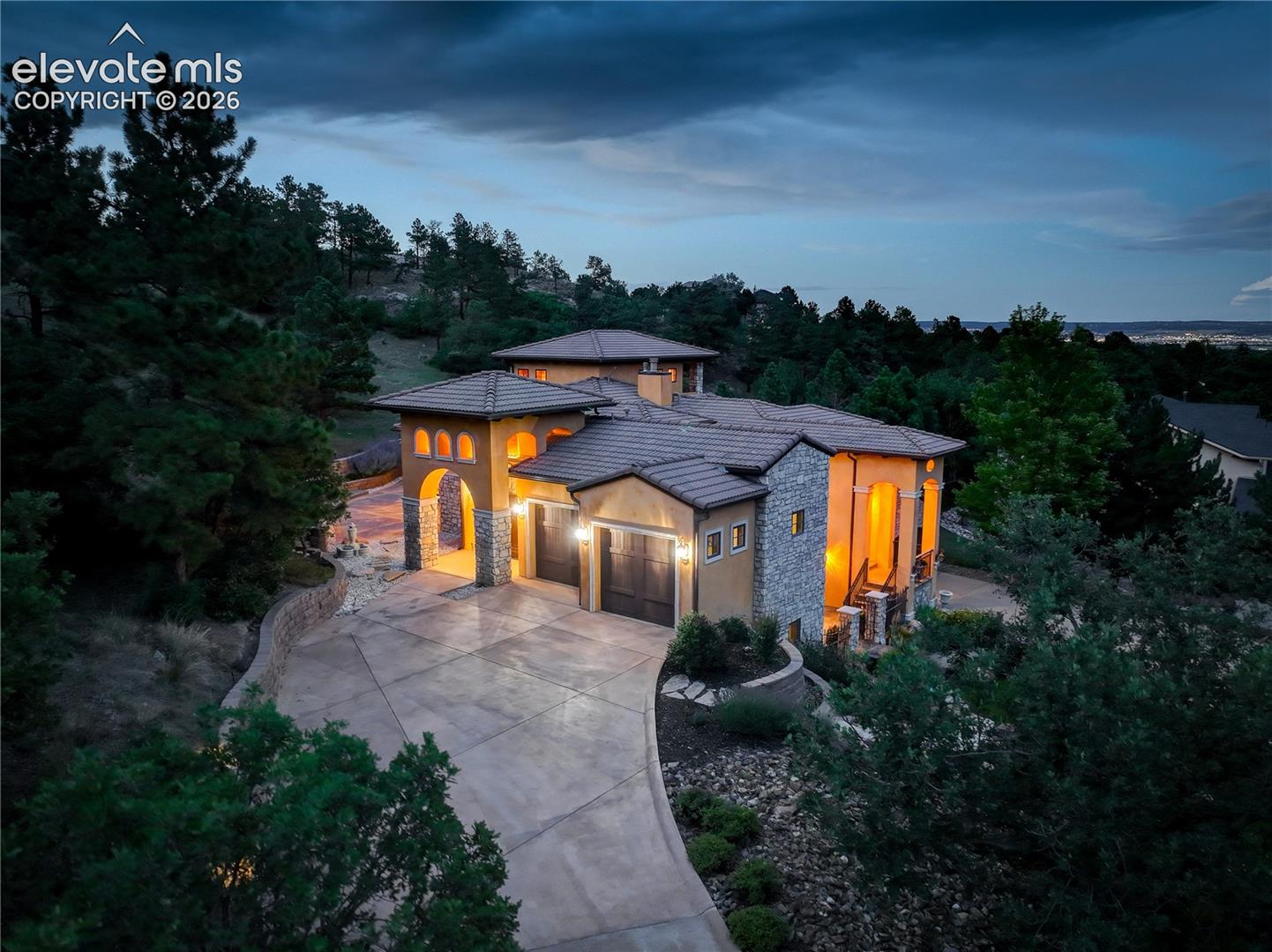 View of residence, with twinkling city lights beyond.