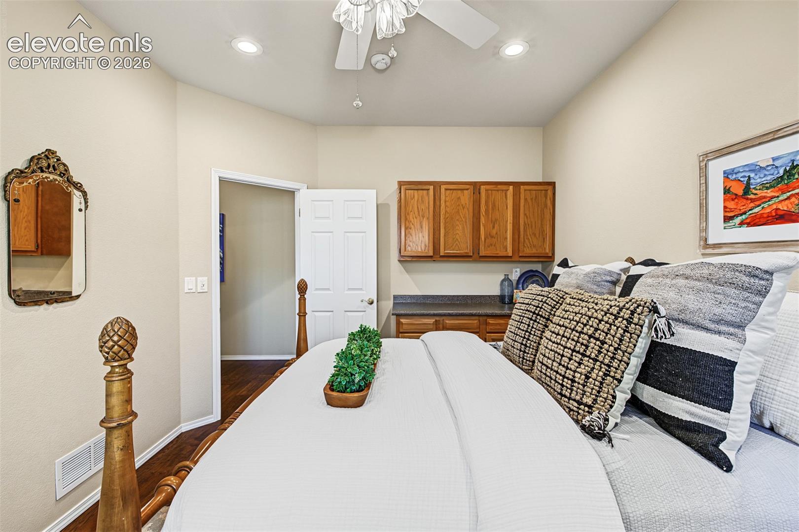 Additional view of the main-level bedroom featuring built-in cabinetry, countertop space, hardwood flooring, and recessed lighting.