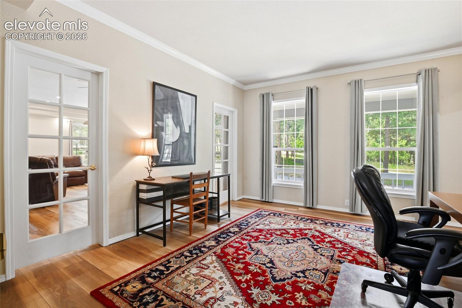 The office has the same newer LVP flooring throughout, glass doors, and crown molding