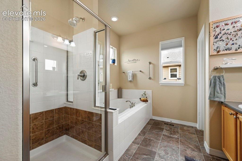 Walk-in shower with clear glass enclosure and tile surround