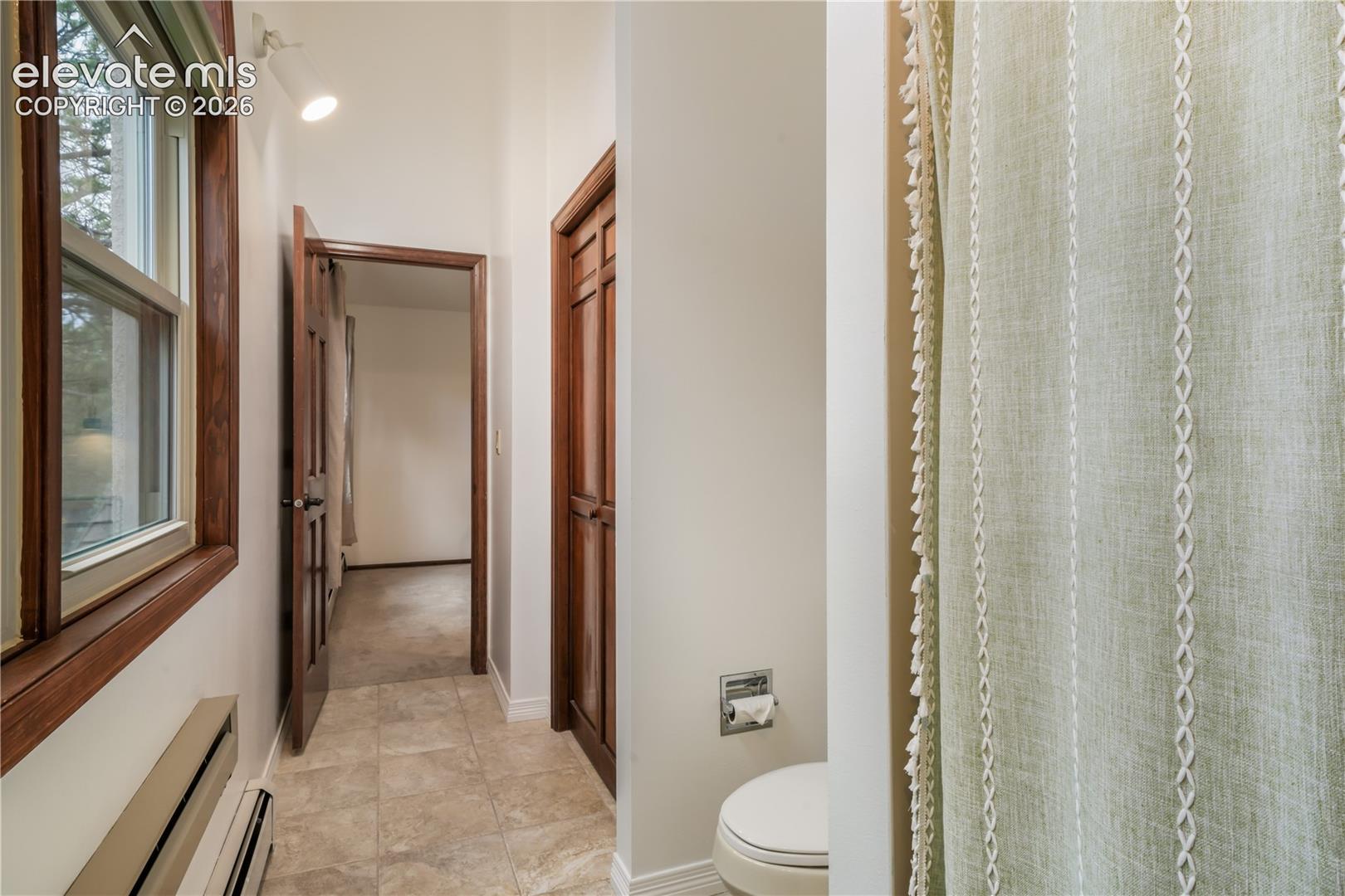 Shared bathroom with tile flooring and large linen closet