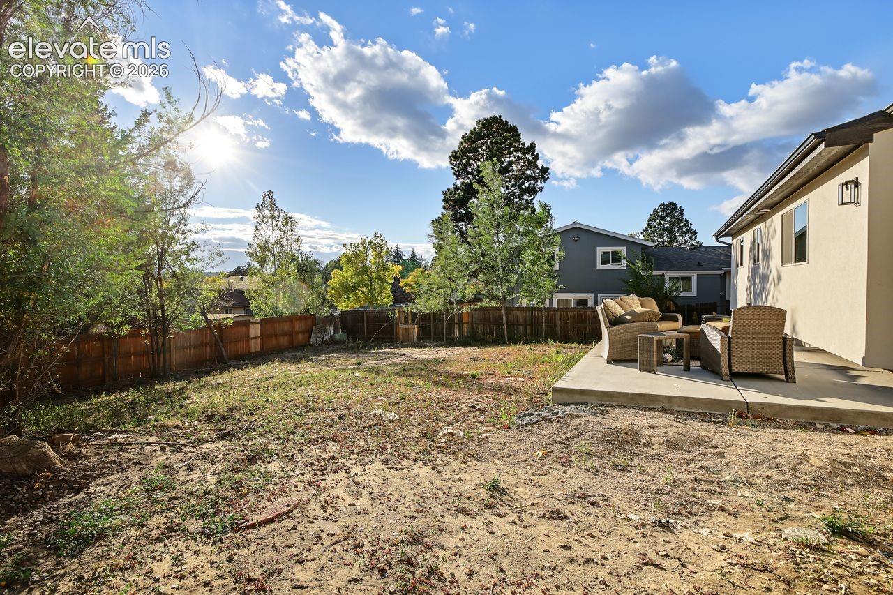 Exterior backyard space featuring a concrete patio, wood-slat privacy fencing.