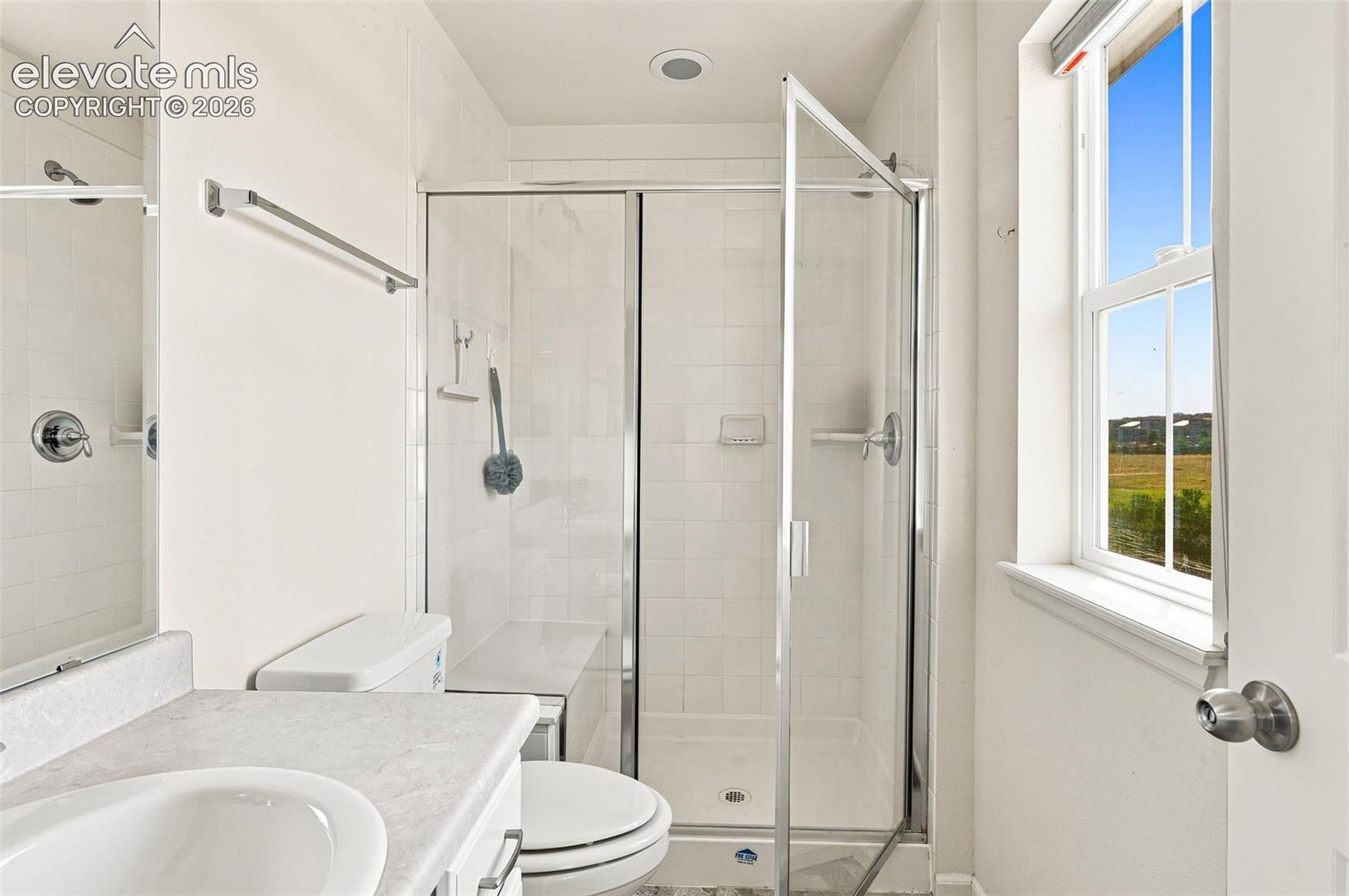 En suite to primary bedroom with large shower and tile floor