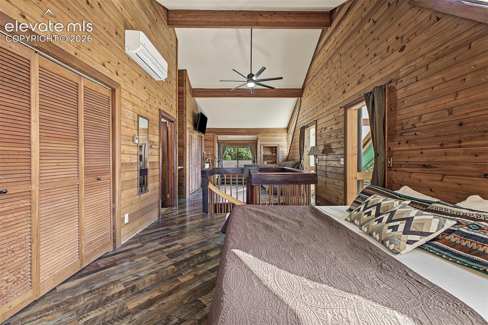 Wood-finish flooring with horizontal wood paneling and vaulted ceilings