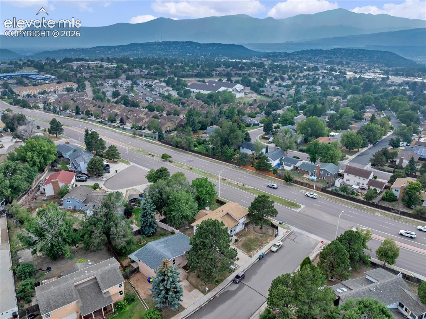 Established residential area featuring mature trees and mountain backdrops