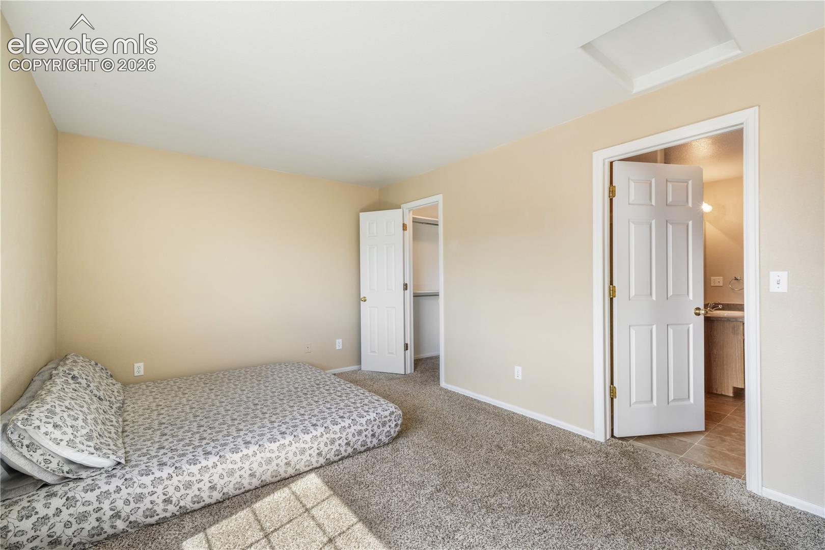 Main level primary bedroom with walk in closets and ensuite bathroom with 2 vanities, 2 separate showers