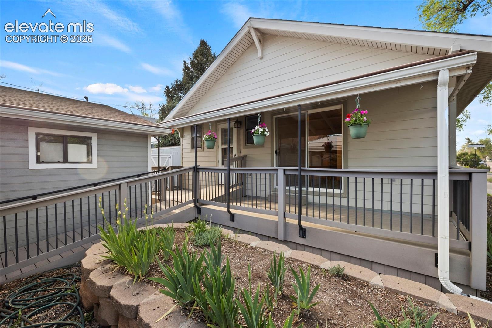 Front exterior featuring siding, covered porch, sliding glass door, and exterior ramp