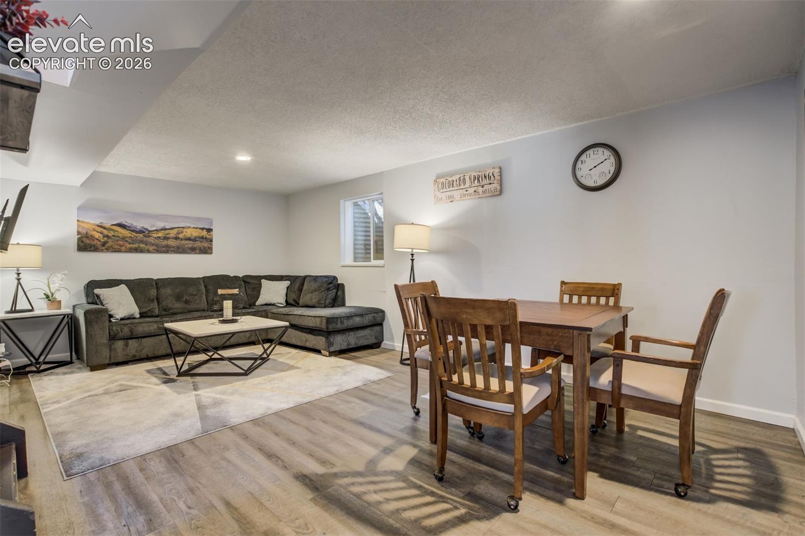 Wood-finish flooring throughout, light gray wall finishes, and recessed ceiling lighting