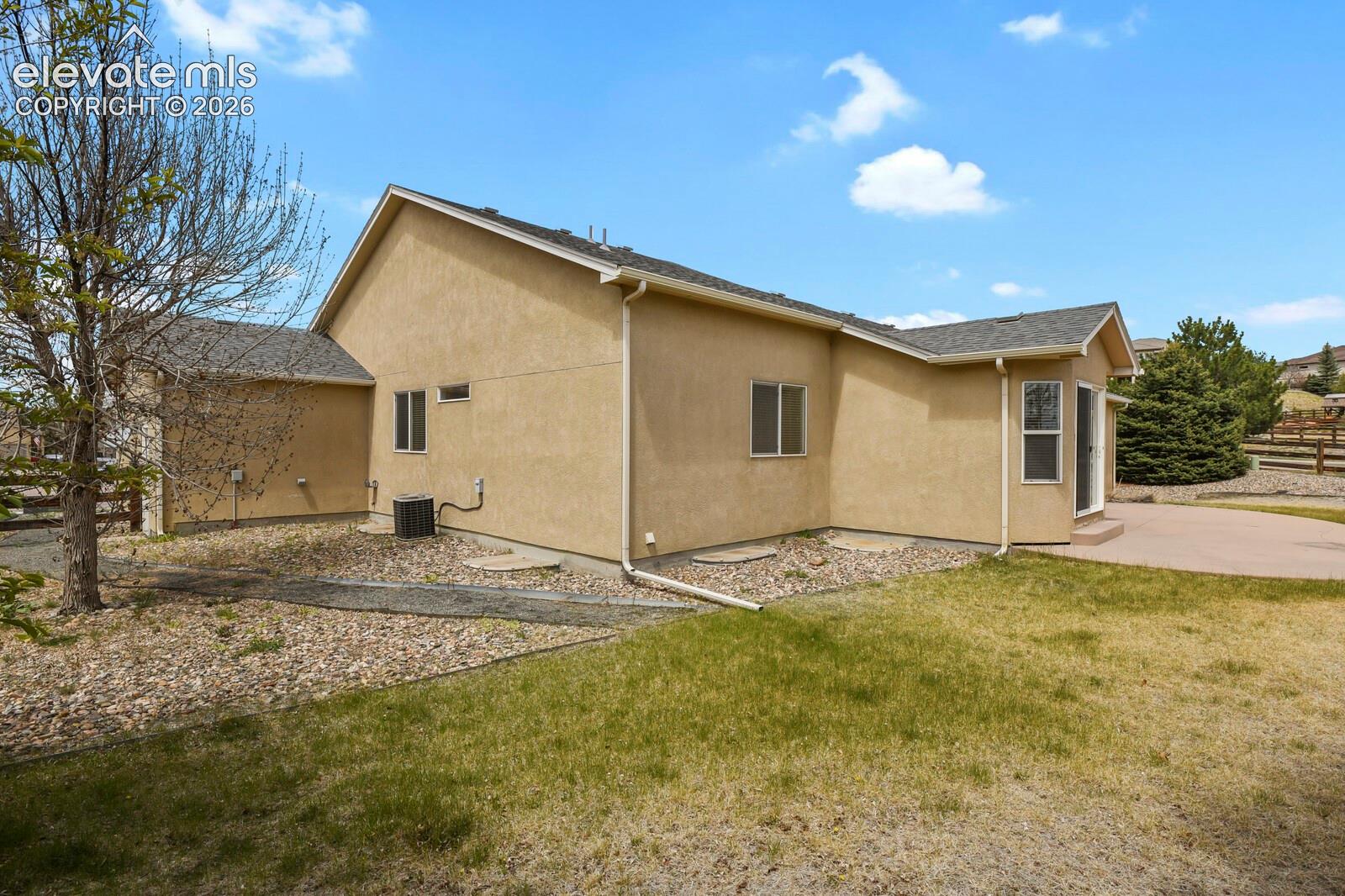 Stucco exterior featuring multiple windows and a curved patio