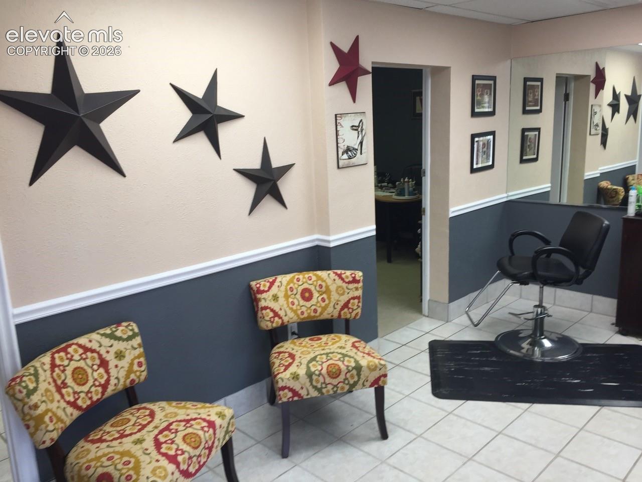 Tiled flooring, two-tone wall paint, built-in wall mirror, and an open doorway