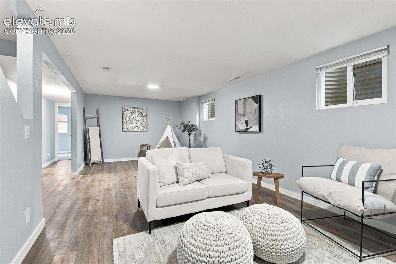 Neutral-toned interior featuring wood-finish flooring, recessed lighting, and egress-style windows
